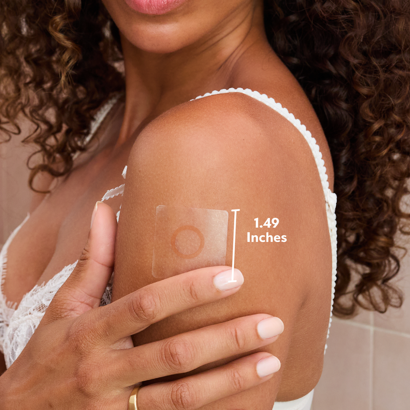 Woman applying a adhesive patch on her arm with measurement label